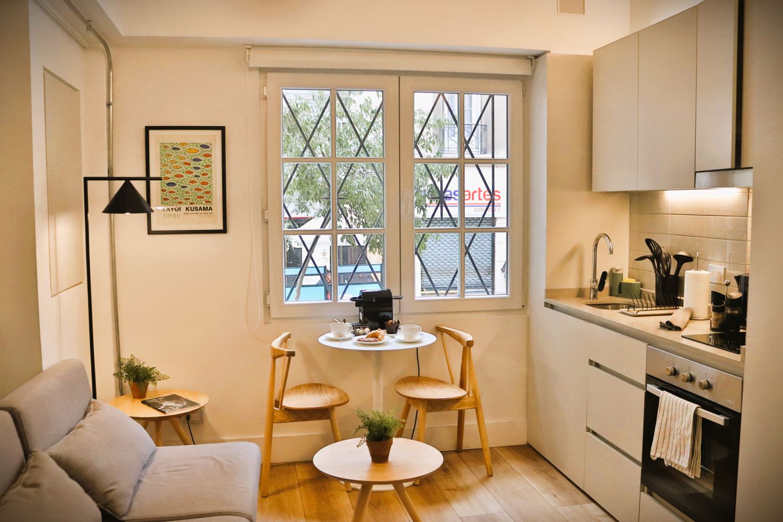 Studio equipado con kitchenette, mesa para dos personas y ventana hacia la calle