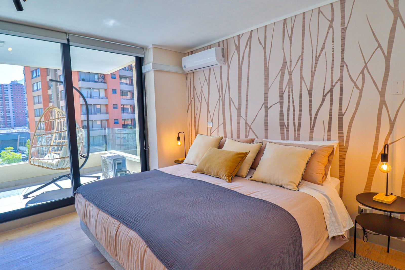 Dormitorio principal con papel mural de troncos, aire acondicionado y salida a la terraza