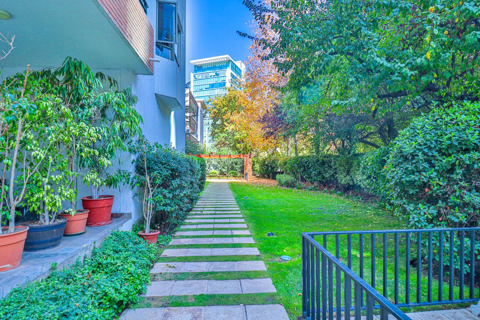 Jardín interior del edificio con sendero de piedra y áreas verdes mantenidas